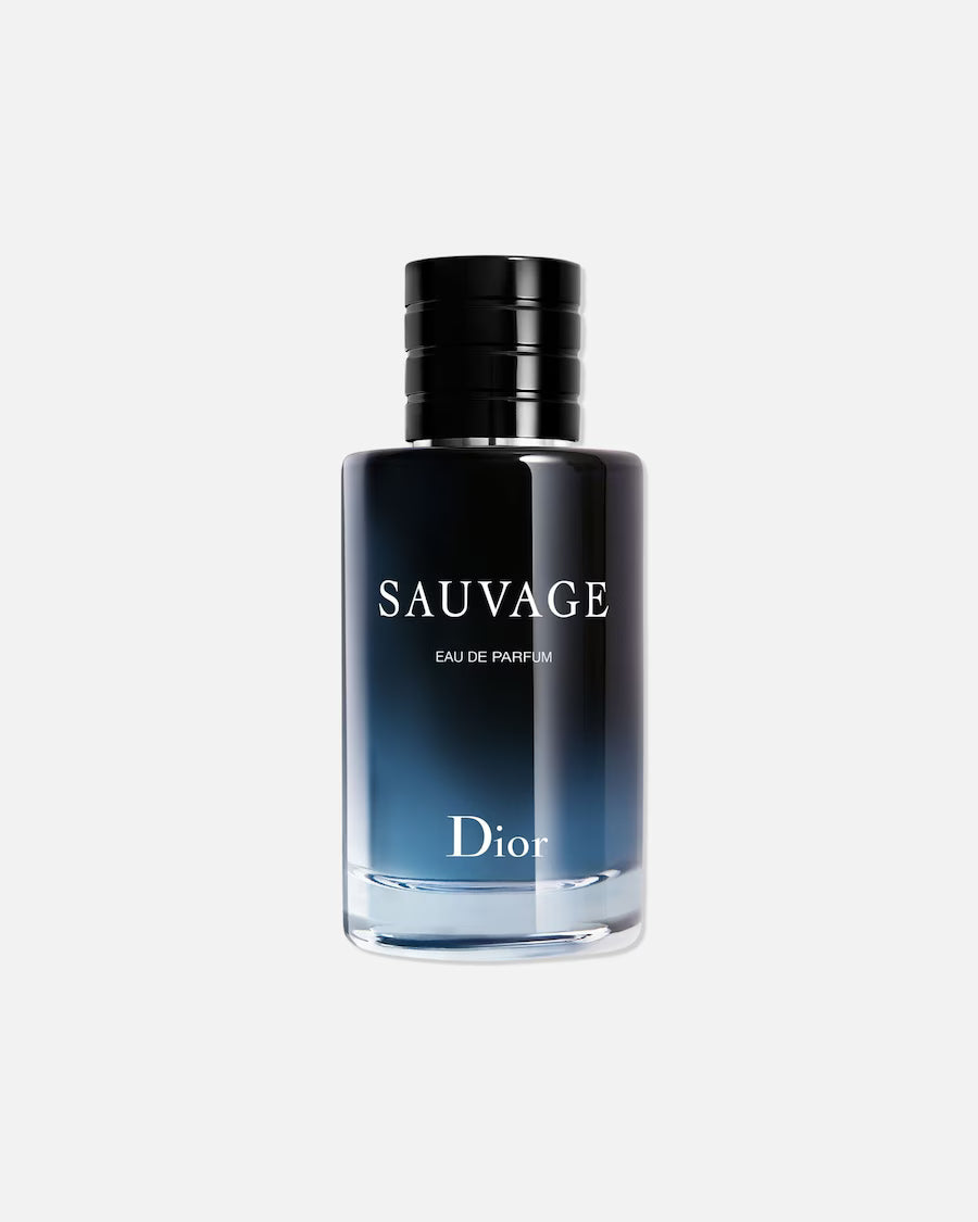 Vrijstaande flacon van Dior Sauvage Eau de Parfum tegen een lichte achtergrond. De glazen fles toont het kenmerkende kleurverloop van helderblauw aan de onderkant naar middernachtblauw aan de bovenkant, afgesloten met een zwarte, geribbelde dop.