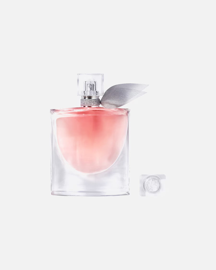 Productfoto van Lancôme La Vie Est Belle Eau de Parfum (75 ml). De elegante flacon met roze vloeistof en een zilveren strik om de hals staat rechts naast de witte doos met glinsterende roze randen.