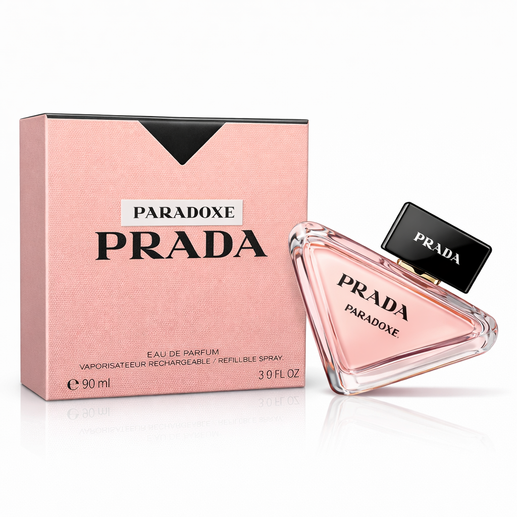 Productfoto van Prada Paradoxe Eau de Parfum (90 ml). De kenmerkende driehoekige glazen flacon met lichtroze inhoud en zwarte dop leunt rechts tegen de bijpassende roze, getextureerde doos.