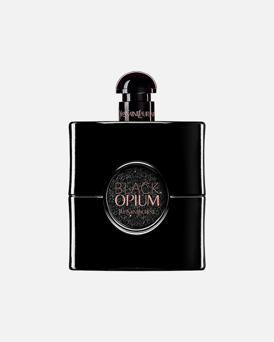 Vrijstaande flacon van Yves Saint Laurent Black Opium Le Parfum. De glanzend zwarte fles heeft een rond, glinsterend venster in het midden met de productnaam in roségoud en een bijpassende zwarte dop.